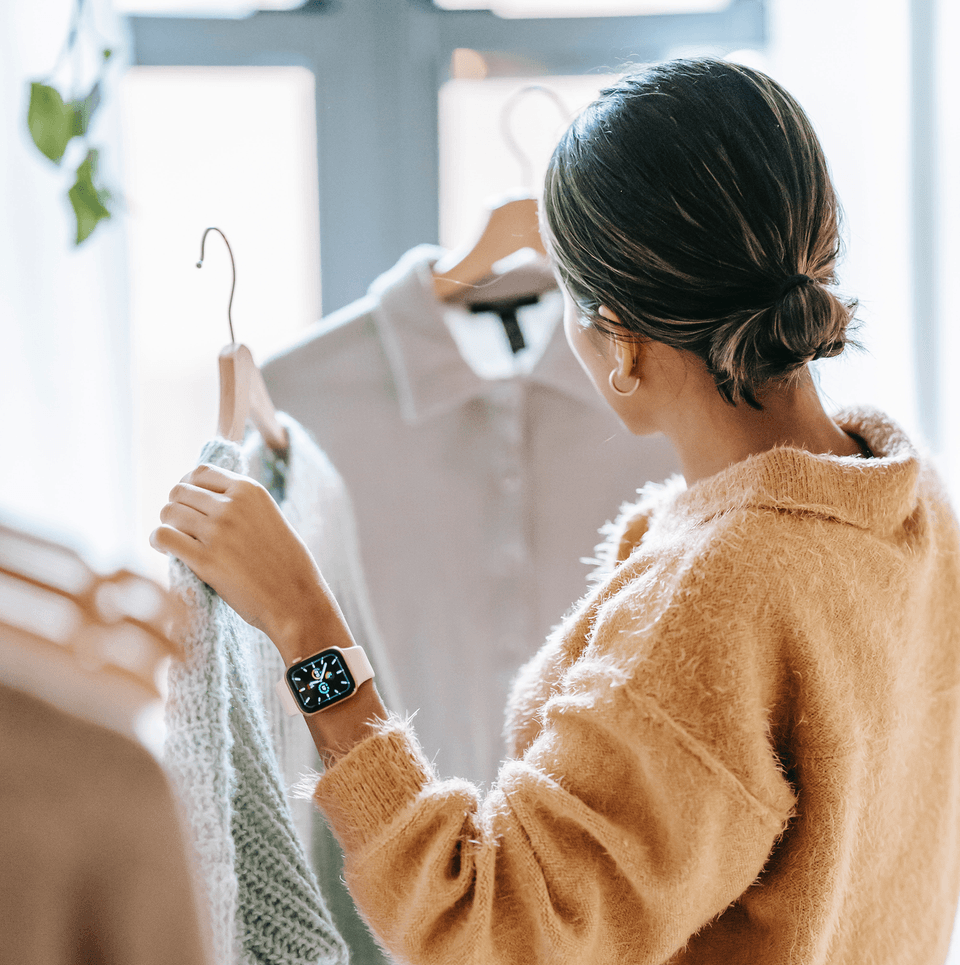 Woman holding clothes while shoping