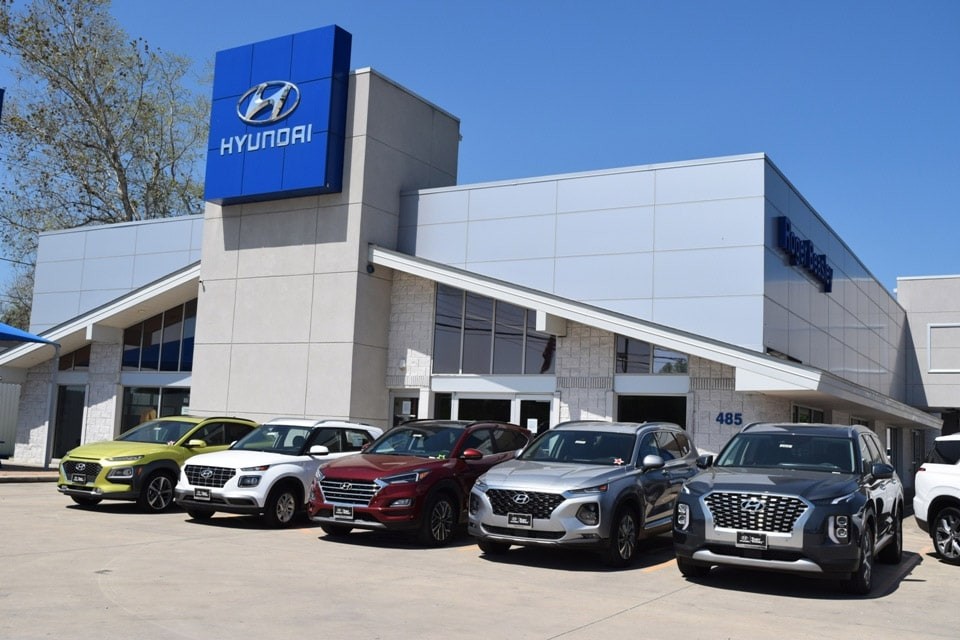 Front of Hyundai dealership with cars parked on the parking lot.