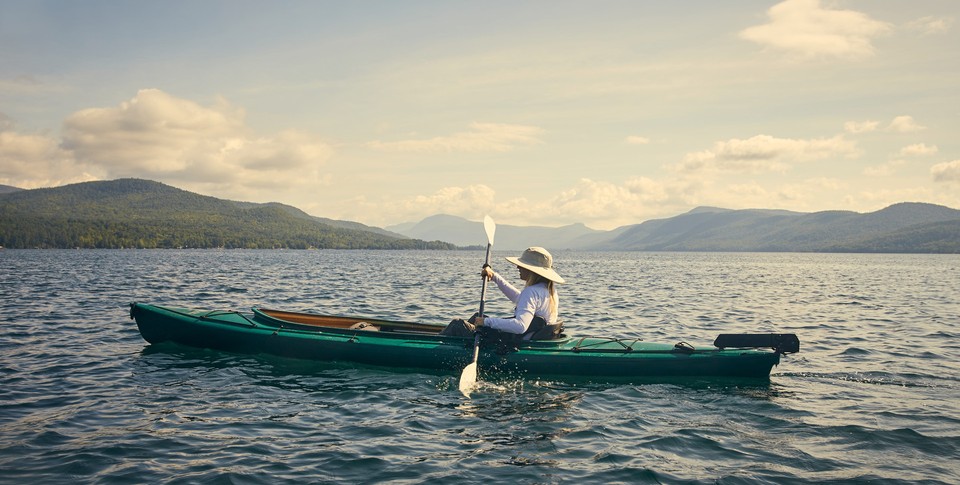 woman paddling canoe on lake