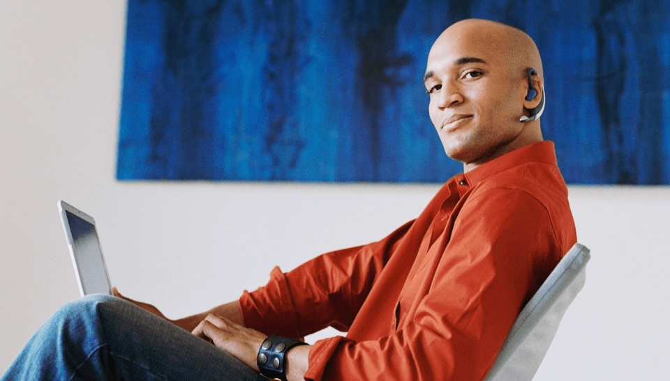 man sitting on sofa holding a loptop