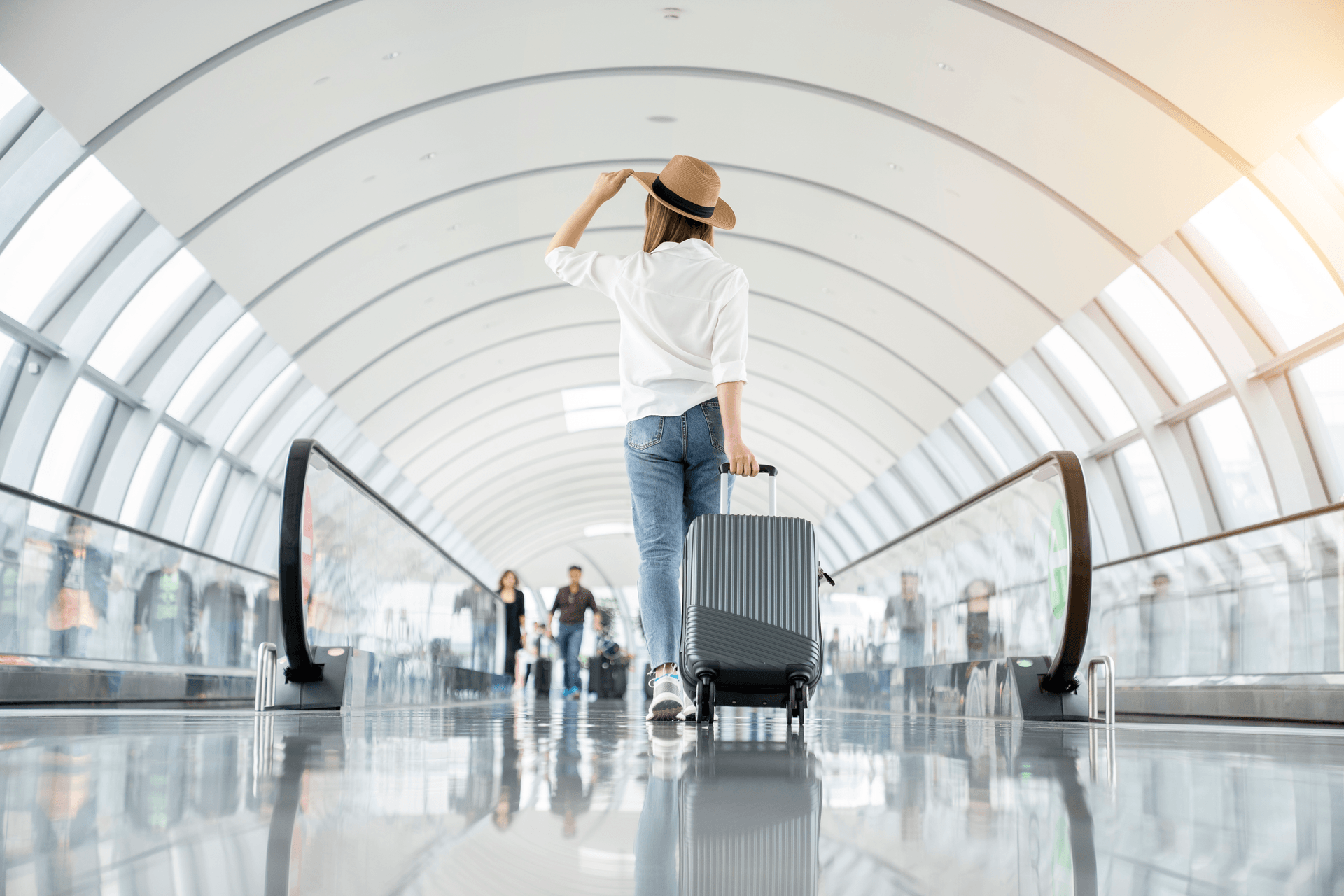 lady pulling roller suitcase through an airport