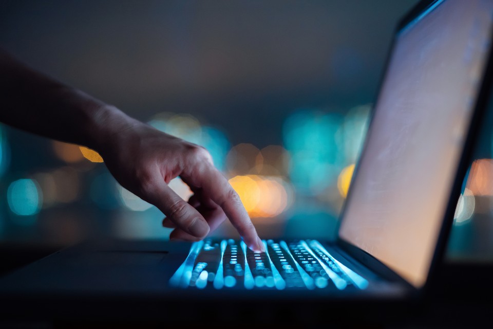 person on a computer in a dark room