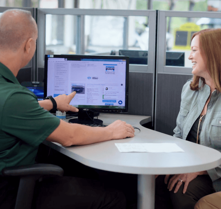 man and woman at table looking at screen