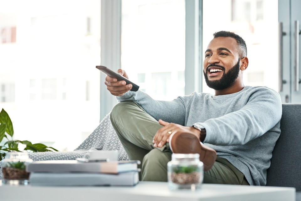 man on couch with remote