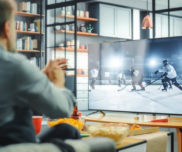 Friends watching a live hockey game on TV at home