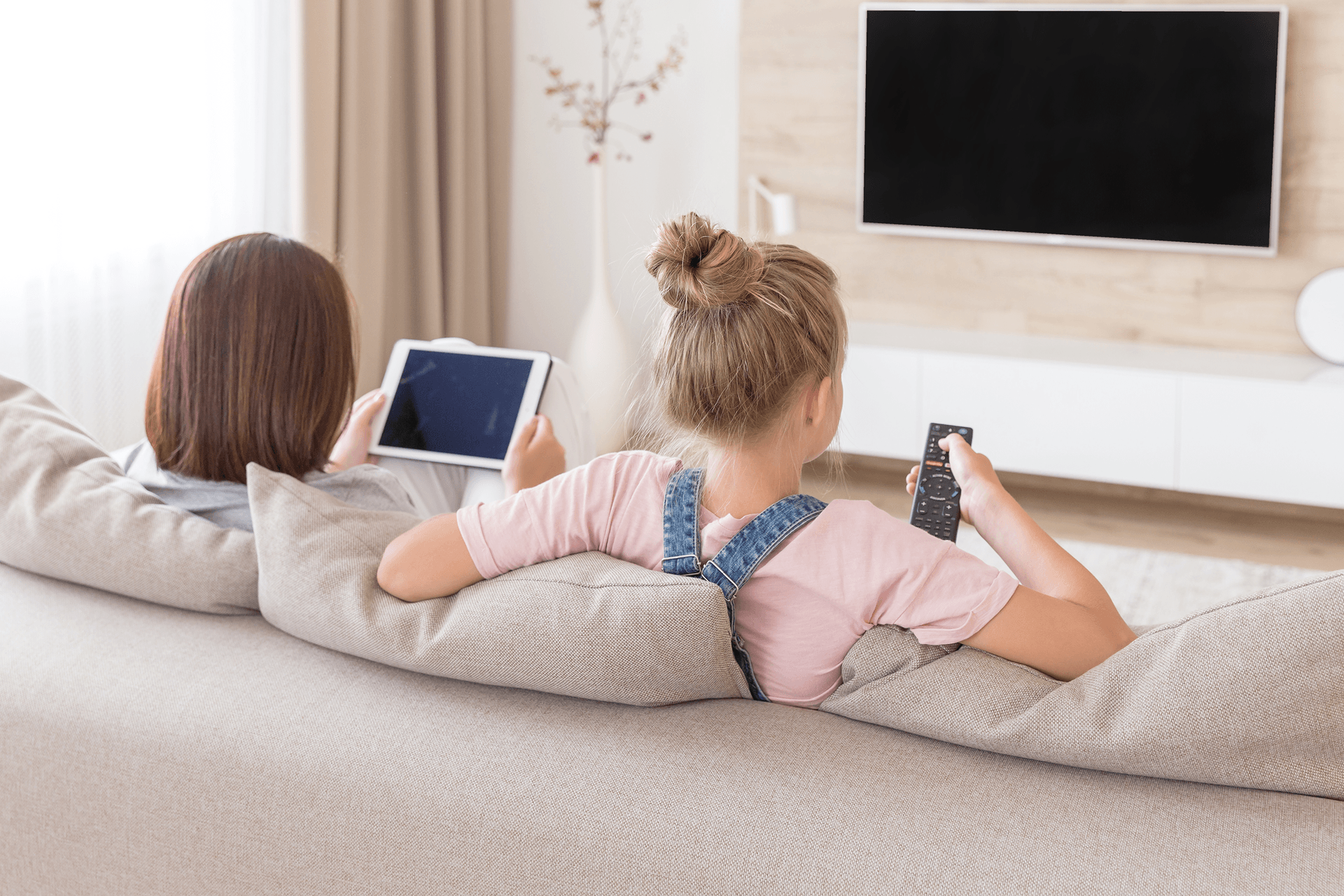 Two women watching tv and a tablet