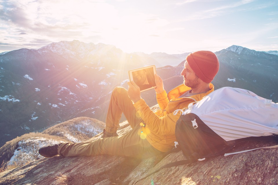 man viewing content on a tablet in a remote location